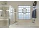 Bright bathroom featuring glass shower, soaking tub, and glass block window at 20331 N Fletcher Way, Peoria, AZ 85382