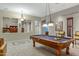 Beautifully appointed game room featuring a classic pool table and elegant chandelier lighting at 20331 N Fletcher Way, Peoria, AZ 85382