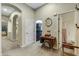 Hallway leading to kitchen and bathroom featuring decorative sewing machine table and arched doorways at 20331 N Fletcher Way, Peoria, AZ 85382