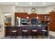 A kitchen featuring dark wood cabinetry, a large island with seating, and stainless steel appliances at 20331 N Fletcher Way, Peoria, AZ 85382