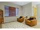 Cozy living area featuring leather chairs, neutral walls, and natural light from the window at 20331 N Fletcher Way, Peoria, AZ 85382