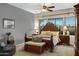 Spacious main bedroom features a wooden bed frame, ceiling fan, and bright windows at 20331 N Fletcher Way, Peoria, AZ 85382