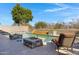 Outdoor pool area featuring a built-in waterfall feature, seating areas, and mature trees at 20331 N Fletcher Way, Peoria, AZ 85382