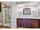 Bathroom featuring a wood vanity, tiled shower, and modern lighting fixtures at 2102 W Marlette Ave, Phoenix, AZ 85015
