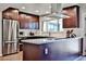 Modern kitchen featuring stainless steel appliances, dark wood cabinets, and a center island with counter seating at 2102 W Marlette Ave, Phoenix, AZ 85015