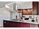 Well-lit kitchen featuring stainless steel appliances, wood cabinets, and a modern range hood at 2102 W Marlette Ave, Phoenix, AZ 85015