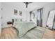 This bedroom has a ceiling fan, light wood floors, a large window and modern décor at 2202 E Lincoln Dr, Phoenix, AZ 85016