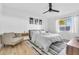 This bedroom features a large window, ceiling fan, modern decor, light wood floors and a comfortable sitting chair at 2202 E Lincoln Dr, Phoenix, AZ 85016
