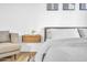 This bedroom features light wood floors, floating nightstand, modern décor, a sitting chair and a large window at 2202 E Lincoln Dr, Phoenix, AZ 85016