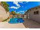Private backyard featuring a sparkling pool, mature trees, and a rock waterfall at 2202 E Lincoln Dr, Phoenix, AZ 85016