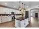 Bright kitchen features a large center island, white cabinetry, stainless steel appliances, and wood-look floors at 23420 N 121St Ave, Sun City, AZ 85373