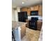 Kitchen with black appliances and light wood cabinets, offering functionality and storage at 25766 W Valley View Dr, Buckeye, AZ 85326