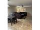 Open-concept living room featuring tile floors, a dining table, and a spacious sectional couch with backyard access at 25766 W Valley View Dr, Buckeye, AZ 85326