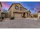 Exterior of tan two-story home with garage, arched entryway, and desert landscaping at 291 N Scott Dr, Chandler, AZ 85225
