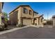 Exterior of tan two-story home with garage, arched entryway, and desert landscaping at 291 N Scott Dr, Chandler, AZ 85225