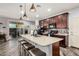 Kitchen featuring a large island with seating, stainless steel appliances, and dark wood cabinetry at 291 N Scott Dr, Chandler, AZ 85225