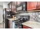 Close-up of kitchen featuring stainless steel appliances, granite countertops, and tile backsplash at 291 N Scott Dr, Chandler, AZ 85225