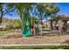 Community playground surrounded by mature trees and greenery with a covered picnic area nearby at 291 N Scott Dr, Chandler, AZ 85225
