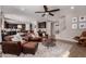 Open-concept living room with a leather sofa, ottoman, and a view of the modern kitchen and staircase at 3192 N Park St, Buckeye, AZ 85396