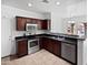 Well-lit kitchen featuring stainless steel appliances, tile flooring, and dark wood cabinets at 3316 W Hayduk Rd, Laveen, AZ 85339