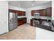 Well-equipped kitchen featuring stainless steel appliances, dark wood cabinetry, and tiled flooring at 3316 W Hayduk Rd, Laveen, AZ 85339