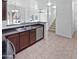 Open kitchen featuring tile flooring, a stainless steel dishwasher, and bar seating area at 3316 W Hayduk Rd, Laveen, AZ 85339