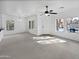 Open living space with neutral carpet, a ceiling fan, and abundant natural light from multiple windows at 3316 W Hayduk Rd, Laveen, AZ 85339