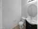 Simple powder room with a dark vanity, round mirror, and tile floors at 3316 W Hayduk Rd, Laveen, AZ 85339