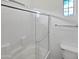 Clean white tiled shower with glass door, window and towel rack in bathroom at 3316 W Hayduk Rd, Laveen, AZ 85339