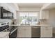 A bright kitchen featuring stainless steel appliances, white cabinets and countertop, and marble backsplash at 3369 W Sandra Ter, Phoenix, AZ 85053