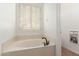 Bathroom featuring a jacuzzi-style tub with black hardware fixtures and shuttered window at 35210 N 26Th Dr, Phoenix, AZ 85086