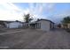 Simple one-story house featuring a covered entry, paved driveway and perimeter fence at 3640 W Garfield St, Phoenix, AZ 85009