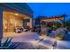 Beautiful backyard with a covered patio, a pergola, lush plants, and outdoor lighting at 3859 E Wood Dr, Chandler, AZ 85249