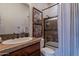 Classic bathroom with a tiled shower, decorative accents, and a vanity with a tile countertop at 3859 E Wood Dr, Chandler, AZ 85249