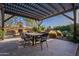 Spacious covered patio with an outdoor dining area, fireplace, and lush landscaping at 3859 E Wood Dr, Chandler, AZ 85249