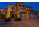 Elegant two-story home with a well-lit entrance, a three-car garage and manicured landscaping at 3859 E Wood Dr, Chandler, AZ 85249