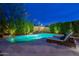 Beautiful backyard pool with lounge chairs and lush green landscaping at dusk at 3859 E Wood Dr, Chandler, AZ 85249
