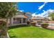 This gorgeous backyard has a grass area, tall trees, and a gated pool at 3938 E Morrison Ranch Pkwy, Gilbert, AZ 85296
