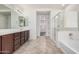 Bathroom with dual sinks, vanity, tile floor, shower and tub combo, and large mirror at 3938 E Morrison Ranch Pkwy, Gilbert, AZ 85296