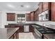 Contemporary kitchen with dark cabinets, granite countertops, and stainless steel gas range at 3938 E Morrison Ranch Pkwy, Gilbert, AZ 85296