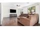 A cozy living room with hardwood floors, a ceiling fan, and a comfortable brown sectional sofa at 3938 E Morrison Ranch Pkwy, Gilbert, AZ 85296