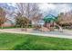 Community playground with slides, climbing structures, and shaded areas surrounded by lush landscaping and green grass at 3938 E Morrison Ranch Pkwy, Gilbert, AZ 85296