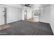 Spacious living room with wood flooring and gray carpeted areas, ceiling fan, and view into the outdoor patio at 4237 E Clovis Ave, Mesa, AZ 85206