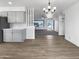 Open living room with gray cabinets, chandelier, wood flooring, and a view of the front yard at 4237 E Clovis Ave, Mesa, AZ 85206