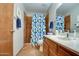 Bathroom featuring blue accented shower curtain, neutral paint, and warm toned tile at 542 S Higley Rd # 102, Mesa, AZ 85206