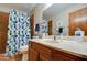 Bathroom featuring blue accented shower curtain, neutral paint, and warm toned tile at 542 S Higley Rd # 102, Mesa, AZ 85206
