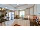 An open kitchen featuring white cabinets, granite counters, and a window view at 542 S Higley Rd # 102, Mesa, AZ 85206