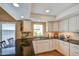 This well-lit kitchen features black granite counters and white cabinets with a window view at 542 S Higley Rd # 102, Mesa, AZ 85206