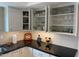 Kitchen features modern white cabinetry, open shelving and under cabinet lighting with black granite countertops at 542 S Higley Rd # 102, Mesa, AZ 85206