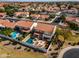 An aerial view of a backyard pool and spa combination with outdoor fireplace and patio seating at 5778 W Corrine Dr, Glendale, AZ 85304